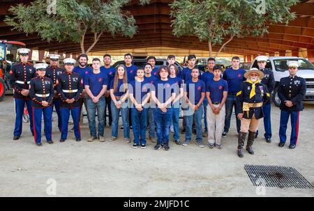 Future Marines in the delayed entry program with Recruiting Sub Station Corona, pose for a group photo with rodeo members after reciting the Oath of Enlistment at the Norco Rodeo, Norco, California, Aug. 28, 2022. The Oath of Enlistment solidifies the individual's promise to support and defend the U.S. Constitution. Stock Photo