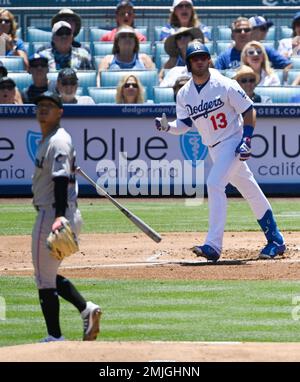 Los Angeles Dodgers' Max Muncy, right, drops his bat after hitting a solo  home run as Miami Marlins starting pitcher Jordan Yamamoto watches during  the first inning of a baseball game Sunday