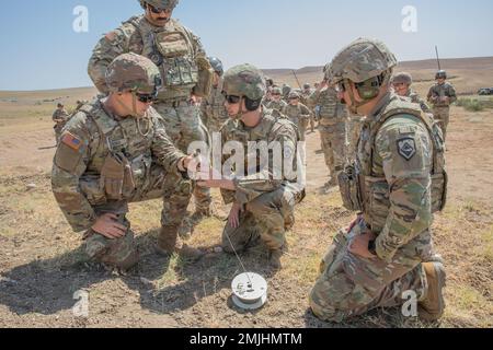 U.S. Army West Virginia National Guard Sgt. Brandon Glasscock (center), a combat engineer assigned to the 119th Sapper Company, demonstrates the sequence of detonation and how to safely operate the initiator to Pvt. Jonathon Ross, a combat engineer assigned to the 119th Sapper Company, during a demolition range held as their first training mission in accordance with Noble Partner located in the Vaziani Training Area, Georgia. Noble Partner is a cooperatively-led multinational training exercise in its sixth iteration between the Georgian Defense Forces (GDF) and U.S. Army Europe and Africa. The Stock Photo