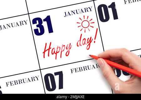 31st day of January. Hand writing the text HAPPY DAY and drawing the sun on the calendar date January 31. Save the date. Holiday. Motivation. Winter m Stock Photo