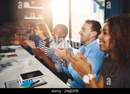 Theyre filled with motivation after that successful presentation. a group of businesspeople applauding a presentation in an office. Stock Photo