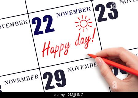 22nd day of November. Hand writing the text HAPPY DAY and drawing the sun on the calendar date November 22. Save the date. Holiday. Motivation. Autumn Stock Photo