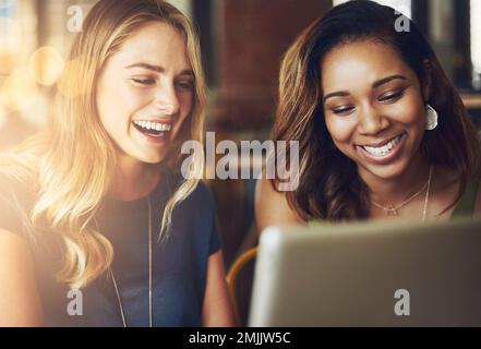 Free wifi is an excuse to do some stalking. girlfriends sharing something on a digital tablet while sitting in a cafe. Stock Photo