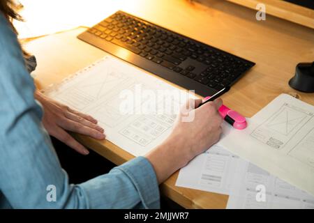 Sketch of wireframe for website. Women designer working on a mobile application, drawing on paper. Stock Photo