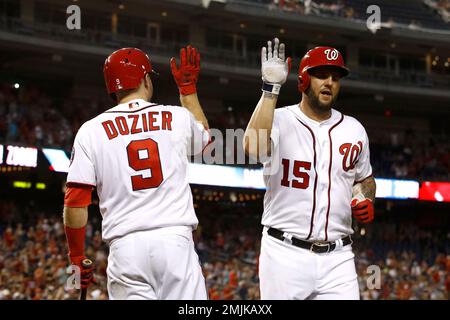 Washington Nationals' Matt Adams, right, celebrates his three-run home run  as Arizona Diamondbacks catcher Caleb Joseph, center, and umpire home plate  Sean Barber (29) look on during the third inning of a