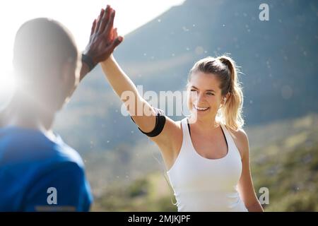 With consistency comes success. a sporty couple high-fiving after a run. Stock Photo