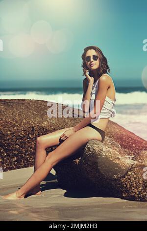 The beach is full of beautiful treasures. an attractive young woman enjoying a day on the beach. Stock Photo