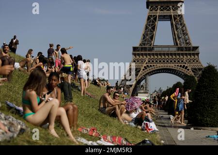 People enjoy the sun on the Trocadero gardens near the Eiffel Tower in Paris, Friday, June 28, 2019. Schools are spraying kids with water and nursing homes are equipping the elderly with hydration sensors as France and other nations battle a record-setting heat wave baking much of Europe. (AP Photo/Lewis Joly)