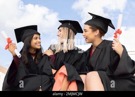 Graduation, education and group of friends celebrate success on sky background. Happy women, diversity students and graduates in celebration of study Stock Photo