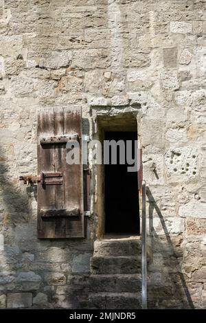 Old wooden door in the old wall. Stock Photo