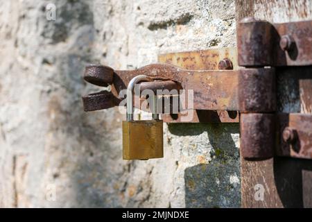 Padlock on an old rusted metal latch. Stock Photo