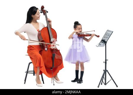 The female teacher guide girl playing Musical Instruments Stock Photo