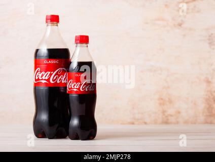 LONDON, UK - AUGUST 03, 2018: Plastic bottles of Original Coca Cola soft drink on wood. Most popular drink in the world Stock Photo