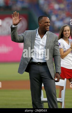 Retired Texas Rangers player, Adrian Beltre (left) signals to the crowd  while sitting with his family during a ceremony where his Texas Rangers  jersey was retired before the second baseball game of