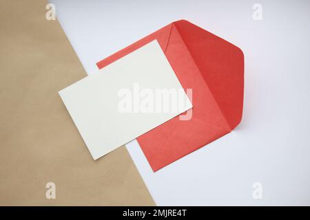 postcard mockup horizontal, on white and brown background red open envelope and white sheet Stock Photo