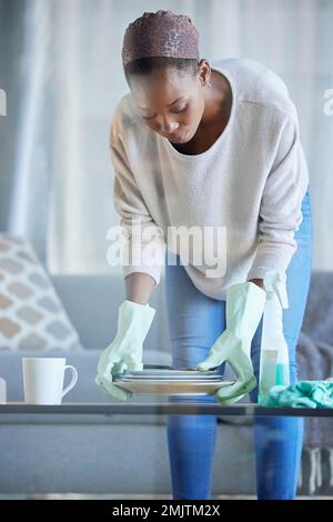 Black woman, cleaner and home spring cleaning of a professional maid holding dirty dishes. Working, housekeeper and focus of a female in a living room Stock Photo