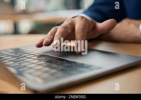 Male office worker using touchpad while working on laptop Stock Photo