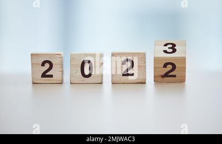 Calendar, 2023 countdown and wooden blocks on empty table in grey studio background for goals or resolution. New year, celebrate and start for Stock Photo