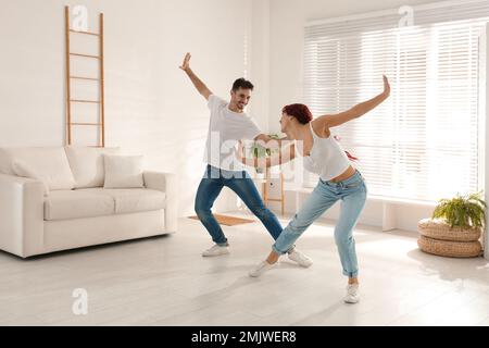 Beautiful young couple dancing in living room Stock Photo