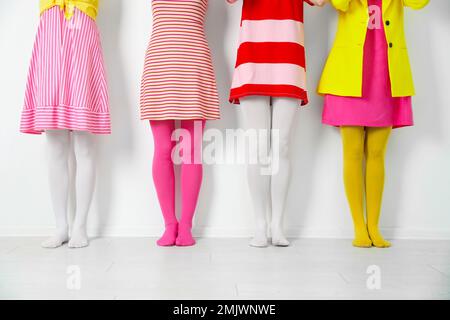 Women wearing colorful tights near white wall, closeup Stock Photo