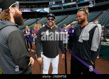 Seven-year-old Tierney Faith Helton, daughter of Colorado Rockies first  baseman Todd Helton, smiles after selecting gum from dispensers in the  dugout as she watches her father take part in a baseball workout