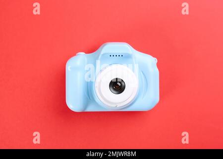 Light blue toy camera on red background, top view Stock Photo
