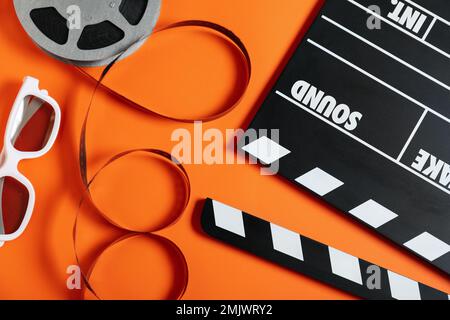 Flat lay composition with clapperboard on orange background. Cinema production Stock Photo