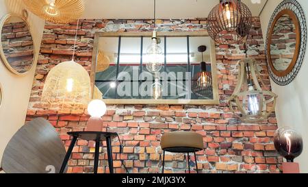 house shop brick red wall retro mirror with different modern chandeliers metal shade pendant decoration Stock Photo