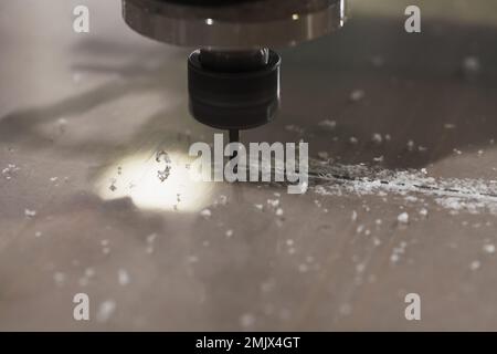 End mill processes a plastic sheet on a CNC milling machine, close-up photo with selective soft focus Stock Photo