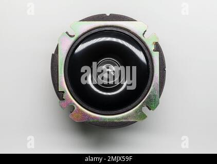Small shiny tweeter, audio speaker lays on a white background with soft ...
