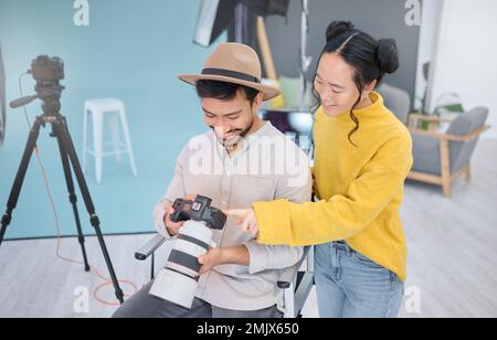 Photography, photographer and model in discussion with a camera choosing a image from the photoshoot. Creative, art and young cameraman talking to Stock Photo