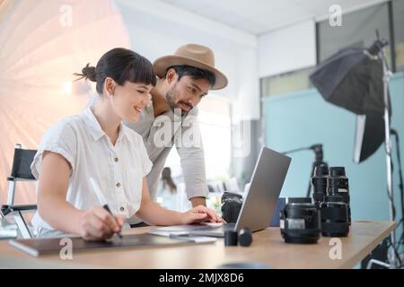 Happy, planning and photographers with work on a laptop, photo shoot results and helping in studio. Teamwork, collaboration and man and woman working Stock Photo