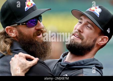 Colorado Rockies' Charlie Blackmon, left, shows to trainer Scott Gehret  where a foul ball hit his batting helmet as he stood in the on-deck circle,  during the third inning of the team's