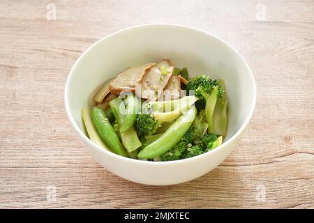 stir fried broccoli with green pea in oyster sauce topping slice grilled pork on bowl Stock Photo