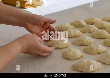 This is homemade potato buns made from yeast dough on white countertop with potatoes in them Stock Photo