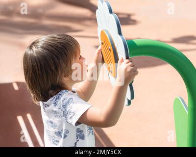 Children Play On A Playground As The Sound Of Bombs And Artillery Fire 