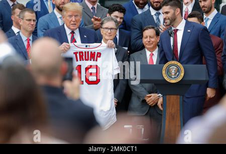 President Donald Trump is presented with a Boston Red Sox baseball team  jersey by Red Sox outfielder J. D. Martinez, during a ceremony on the South  Lawn of the White House in