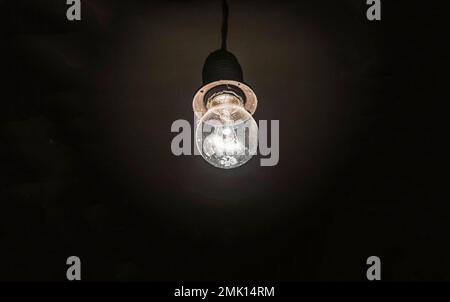 retro photo of old light bulb with dust and cobwebs glows in the dark Stock Photo