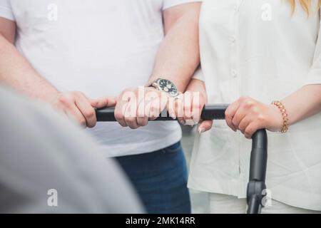married couple is driving a baby stroller Stock Photo