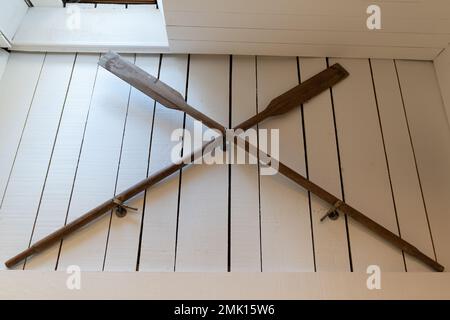 Old wooden boat oars paddle on white wall decoration Stock Photo