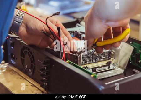 The worker assembles the amplifier to the speaker system Stock Photo