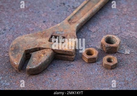 Old wrench and nuts on a rusty countertop Stock Photo