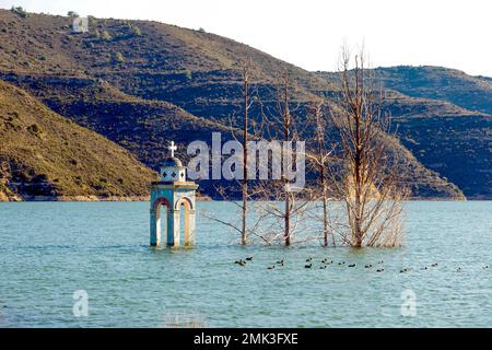 Only the church tower of Alassa still looks out of the water of the Kouris reservoir. Stock Photo
