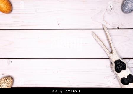 rustic, white wooden table top with subtly colored Easter eggs and wooden Easter bunny Stock Photo