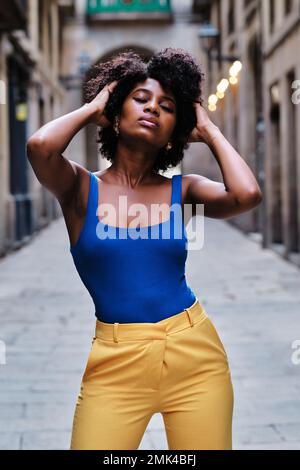 Woman with afro hair posing on the street with her eyes closed. Stock Photo