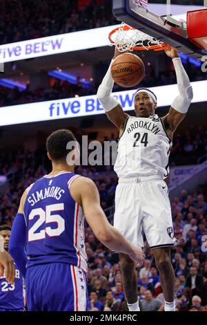 Brooklyn Nets' Ben Simmons, left, dunks as Philadelphia 76ers