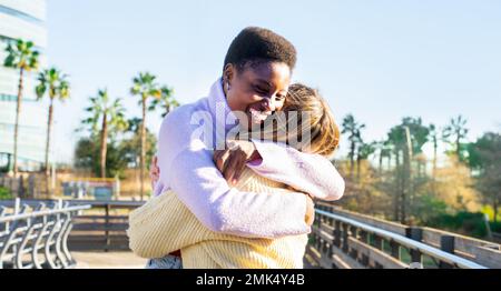 Two girls friends hugging affectionately happy smiling. Women having fun together and embracing. Stock Photo