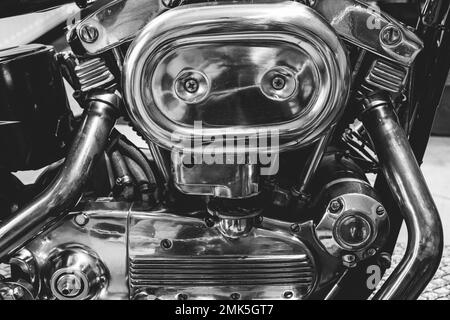Black and white picture of fragment of v-twin engine in old-fashioned chopper. Chrome motor housing. Stock Photo