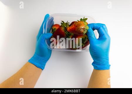 food waste, strawberries with mold in a container on a white background Stock Photo