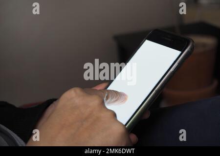Elderly hand holding phone mobile blank screen and finger touch. Stock Photo